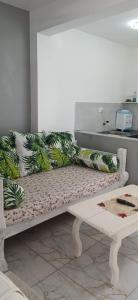 a white bench with green and white pillows on it at Havilla Cecilia in Watamu