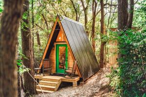a cabin in the woods with a green door at Romantic A-Frame Couples Retreat Cozy and 12 Acres in Rockbridge