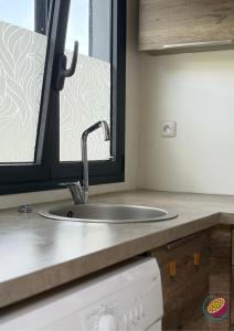 a kitchen counter with a sink and a window at Studio Belle Place in Le Gosier