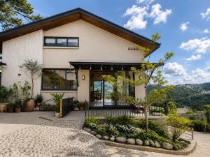 a white house with a tree in front of it at An Valley Villa Đà Lạt in Da Lat