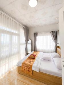 a bedroom with a large bed with white curtains at Lakshmi 2BR House Da Lat in Ấp Phước Thánh +12 photos