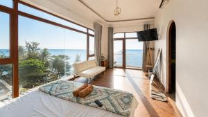 a bedroom with a bed with a view of the ocean at Coco Bay Hon Son in Lai Sơn