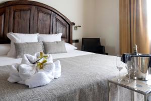 a bed with a white blanket and pillows on top of it at Sa Voga Hotel & Spa in Arenys de Mar