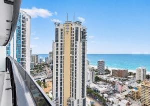 a tall building with the ocean in the background at Circle on Cavill Apartments - Hosted by WowStay in Gold Coast