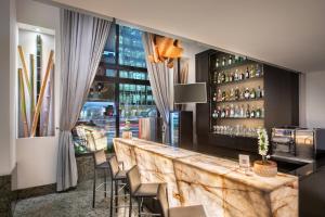 a restaurant with a bar with chairs and a window at Meliá Paulista in São Paulo