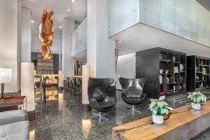 a lobby with two black chairs and a table at Meliá Paulista in São Paulo