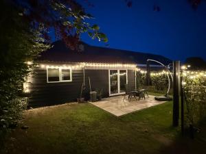 a backyard at night with lights on a house at B&B Tinkunakama in Ouddorp