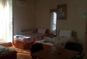 a room with two beds and a table and a window at Apartments Dan Dar in Nov Dojran