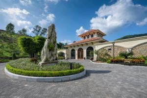 a large building with a statue in front of it at Silk Path Dong Trieu Golf Course & Villas in Trại Sưu