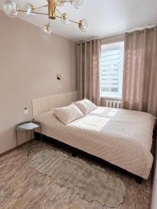 a bedroom with a large bed and a window at SMART flat - Ranna 49 in Sillamäe