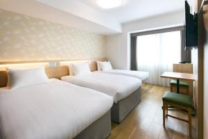 a hotel room with three beds and a desk and a window at Karaksa Hotel Osaka Namba in Osaka +29 photos
