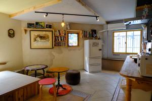 a kitchen with a refrigerator and a table and two stools at The hostel kobe in Kobe