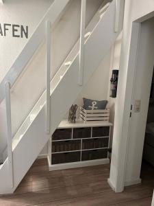 a staircase with a book shelf under the stairs at App "Ahoi" Familie Köhn in Schönberger Strand