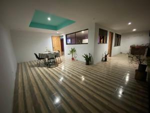 a living room with a table and chairs on a wooden floor at Casa Palo Verde in Bagaces