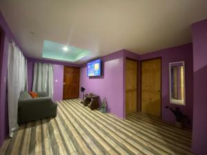 a living room with purple walls and a couch at Casa Palo Verde in Bagaces
