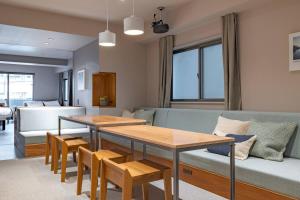 a living room with a couch and a table and chairs at 9STAY Kikukawa in Tokyo