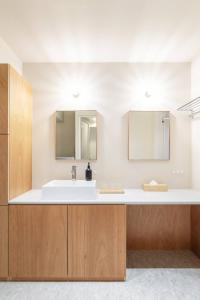 a bathroom with a sink and two mirrors at 9STAY Kikukawa in Tokyo