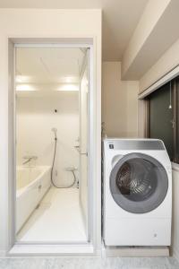 a washing machine in a bathroom with a bath tub at 9STAY Kikukawa in Tokyo +27 photos
