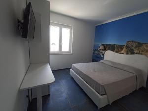 a bedroom with a bed and a tv and a window at AzzurroMare Ponza Rooms Sea View by Caseaponza it in Ponza