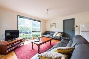 a living room with a couch and a tv at Panorama Retreat & Resort in Kalorama