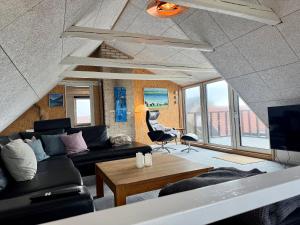a living room with a couch and a table at Charming Townhouse In Thyborøn in Thyborøn