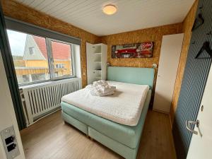 a small bedroom with a bed and a window at Charming Townhouse In Thyborøn in Thyborøn