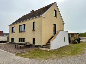 a house with a bench in front of it at Charming Townhouse In Thyborøn in Thyborøn