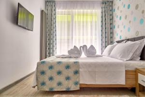 a bedroom with a bed with white sheets and a window at Apartament Alezzi Beach in Năvodari +67 photos