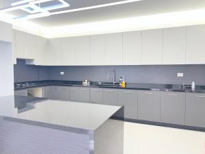a white kitchen with white cabinets and a sink at Countryside Guesthouse in Kafr Nabrakh