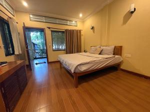 a bedroom with a bed and a wooden floor at Kep Ocean Inn in Kep