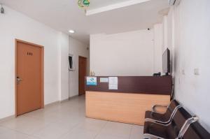 a lobby with a reception desk and chairs in a room at Ava Guesthouse Lampung in Tanjungkarang