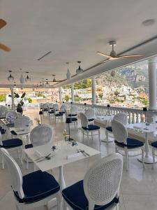 a restaurant with white tables and chairs with a view at Villa Principe Giovanni in Positano