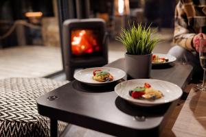 two plates of food on a table with a fireplace at Glamping Babákov in Včelákov +23 photos