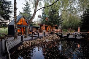 a house with a pond in front of it at Glamping Babákov in Včelákov