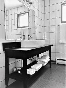 a bathroom with a sink and a mirror and towels at Alpine Inn & Suites in Revelstoke +52 photos