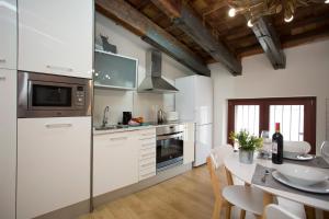 a kitchen with white appliances and a table with chairs at SingularStays San Vicente in Valencia