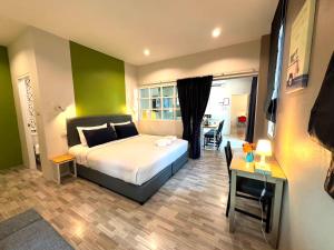 a hotel room with a bed and a desk and a table at The Cube Resort in Chanthaburi