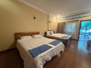 a bedroom with two beds and a window at Kep Ocean Inn in Kep