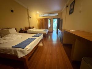 a hotel room with two beds and a desk at Kep Ocean Inn in Kep +28 photos