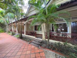 a house with palm trees in front of it at Kep Ocean Inn in Kep