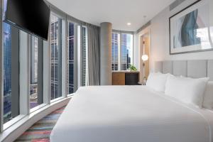 a bedroom with a large white bed and large windows at Brady Hotels Elizabeth Street in Melbourne +11 photos