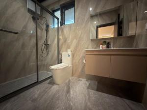 a bathroom with a toilet and a glass shower at Plaza Hotel in Dili