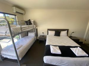 a bedroom with two bunk beds and a window at Dooley's Tavern & Motel Springsure in Springsure