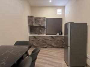 a kitchen with a black counter and a refrigerator at Plaza Hotel in Dili