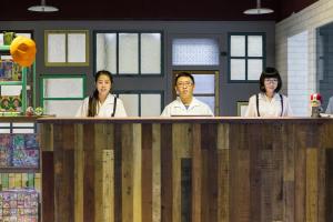 a group of people standing behind a counter at RF Hotel - Sanchong in Taipei