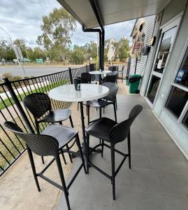 a patio with tables and chairs on a porch at Dooley's Tavern & Motel Springsure in Springsure