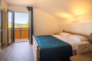 a bedroom with a bed and a large window at Green Escape garni hotel in Postojna