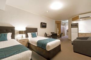 a hotel room with two beds and a couch at Pavilion Hotel Wagga Wagga in Wagga Wagga +65 photos