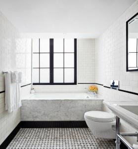 a white bathroom with a tub and a toilet at Walker Hotel Greenwich Village in New York