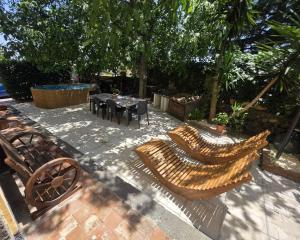 a patio with two benches and a table and chairs at La Dimora del Grifo in Mascalucia